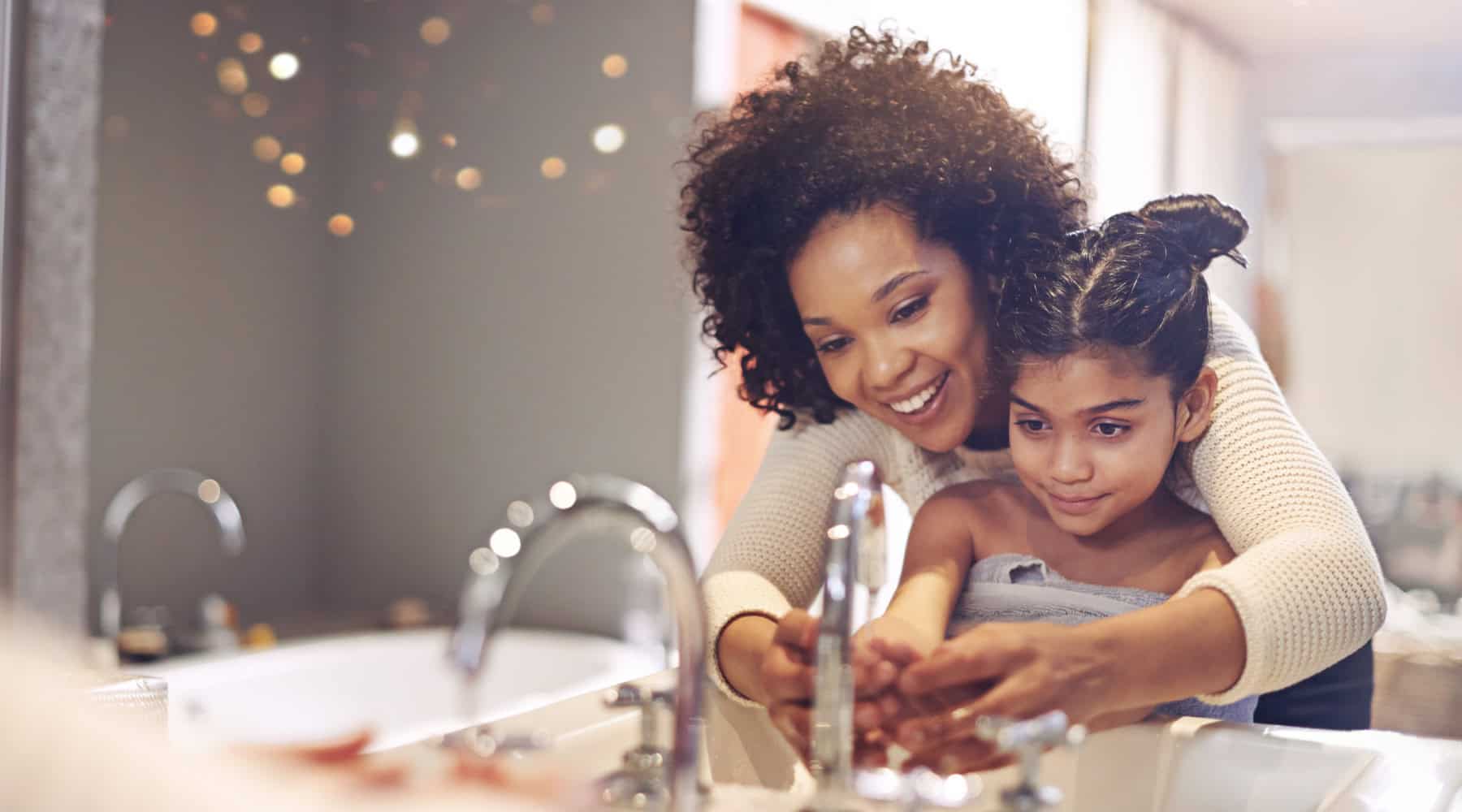 Mom and young daughter washing hands