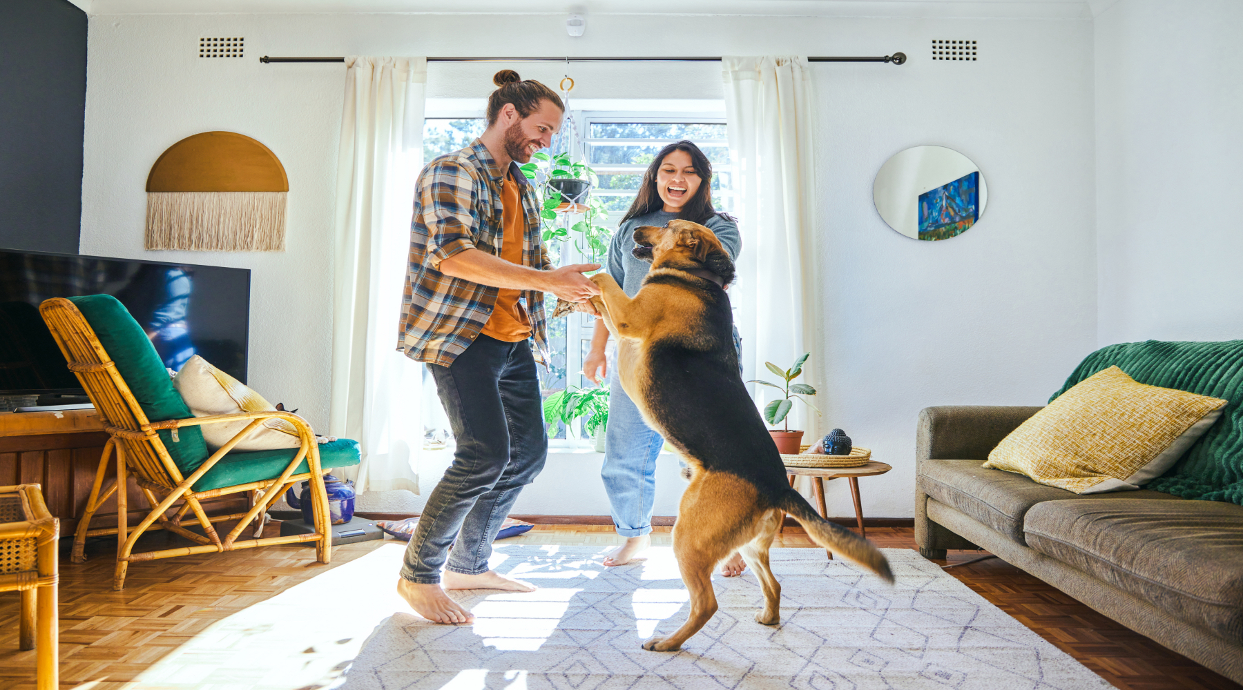 Shot of a young couple playing with their pet dog